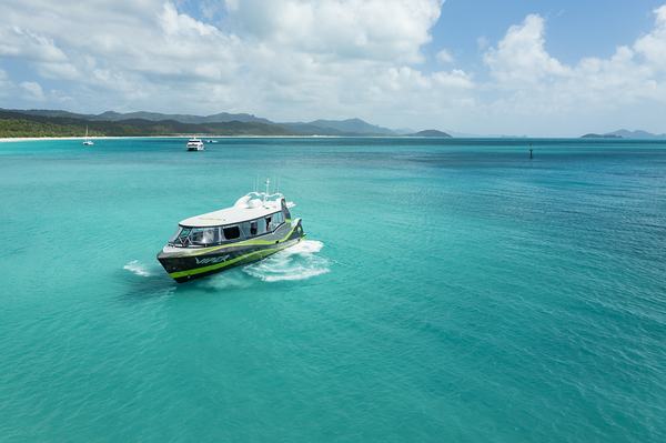 a blue and white boat sitting next to a body of water