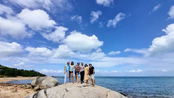 a group of people on a beach near a body of water